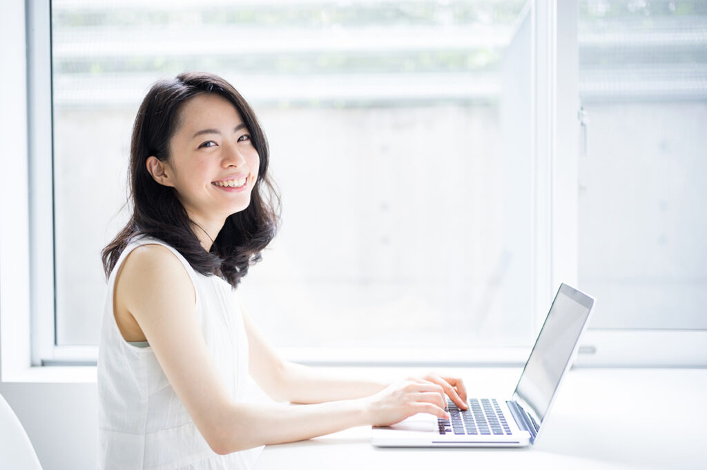 smiling woman in front of laptop